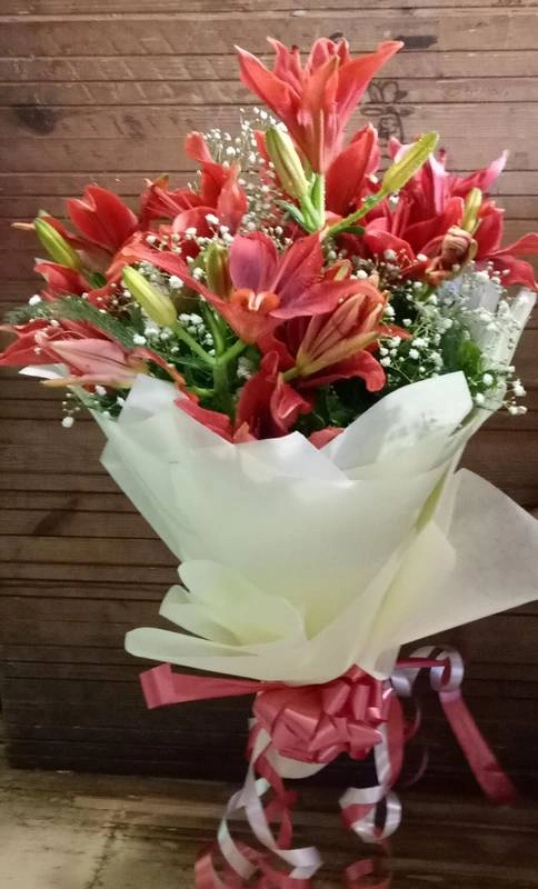 Orange Lilies With White Tissue Paper packing Hand Bouquet Rs 2279